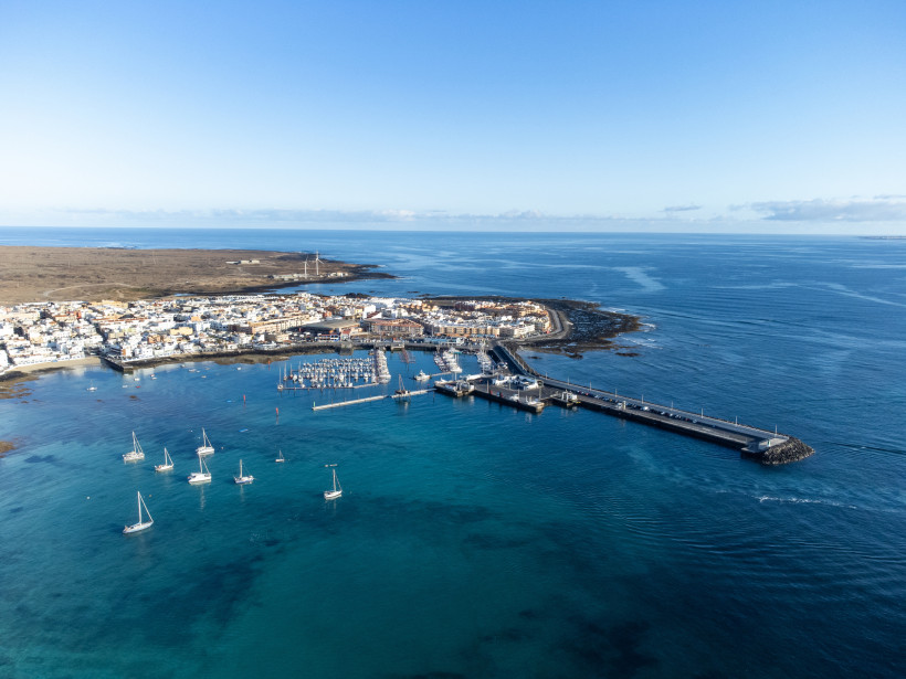 Luftaufnahme des Hafens von Corralejo mit Marina, Booten und Mole am Atlantik