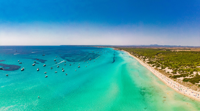 Es Trenc: Strand und türkisfarbenes Meer mit Booten aus der Luft Luftaufnahme des Strandes Es Trenc mit türkisfarbenem Meer und mehreren Booten vor der Küste
