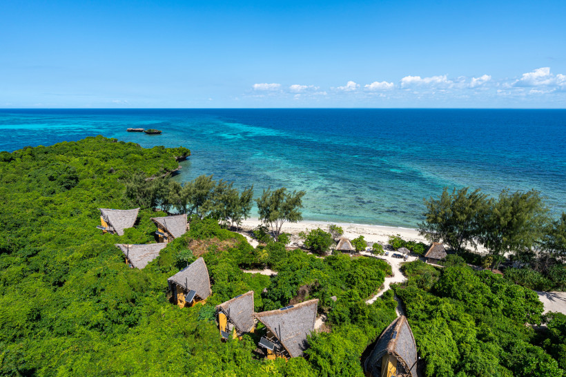Sansibar - Chumbe Island Luftaufnahme von einer Eco-Lodge mit Strohdächern inmitten dichter Vegetation direkt am weißen Strand und dem türkisblauen Meer von Sansibar