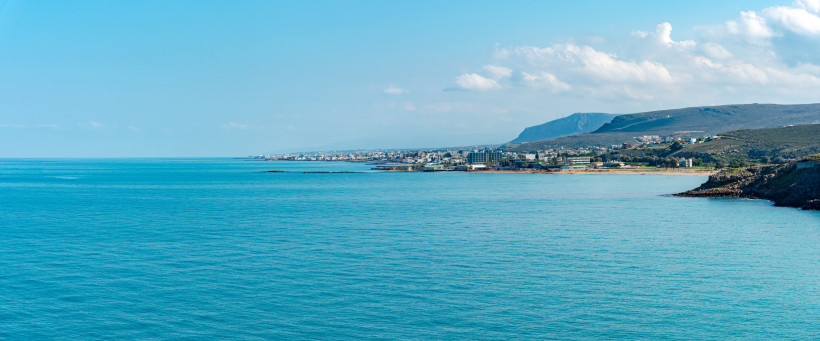 Küste bei Kokkini Hani mit Blick auf das Meer, Küstenort und Berge im Hintergrund