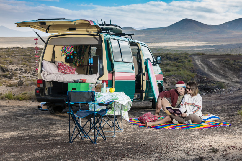 Günstig nach Lanzarote reisen – Roadtrip Paar vor ihrem Camper auf Lanzarote beim entspannten Frühstück in der Natur – ideale Option für budgetfreundliche und flexible Reisen.