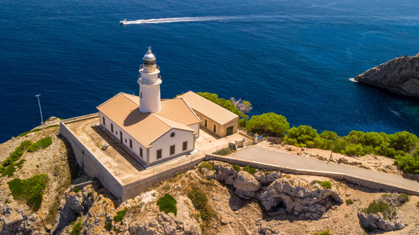 Far de Capdepera bei Cala Ratjada auf Mallorca, Luftaufnahme des Leuchtturms auf einer Steilküste über dem tiefblauen Mittelmeer