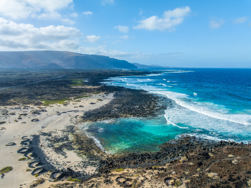 Lanzarote - Caletón Blanco Luftaufnahme der Küste bei Orzola auf Lanzarote mit schwarzem Lavagestein, hellem Sandstrand und türkisblauem Atlantik.