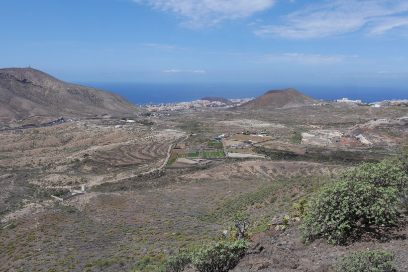 Panoramablick über das trockene Hügelland bei Arona auf Teneriffa mit Küstenort und Atlantik am Horizont