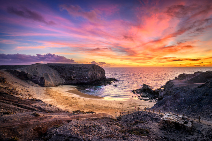 Sonnenuntergang über den Papagayo-Stränden auf Lanzarote mit goldenem Sand und beeindruckenden Felsklippen