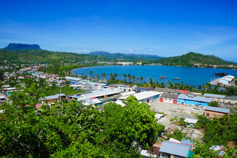 Panoramablick auf die Küstenstadt Baracoa im Osten Kubas mit türkisblauer Bucht, Palmen, bunten Häusern und grünen Hügeln im Hintergrund – ein verstecktes Juwel der Karibik.