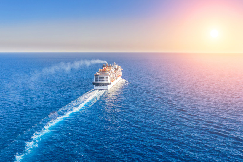 Kreuzfahrtschiff auf dem Atlantik mit Kielwasser bei Sonnenaufgang