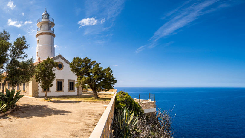 Leuchtturm Far del Cap Gros auf einer Klippe mit Blick auf das Meer