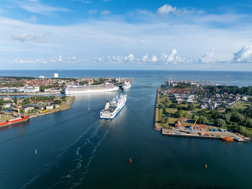 Kreuzfahrten ab Warnemünde: Kreuzfahrtschiffe im Hafen und auf der Zufahrt zur Ostsee Luftaufnahme des Kreuzfahrthafens Warnemünde mit mehreren Schiffen in der Fahrrinne