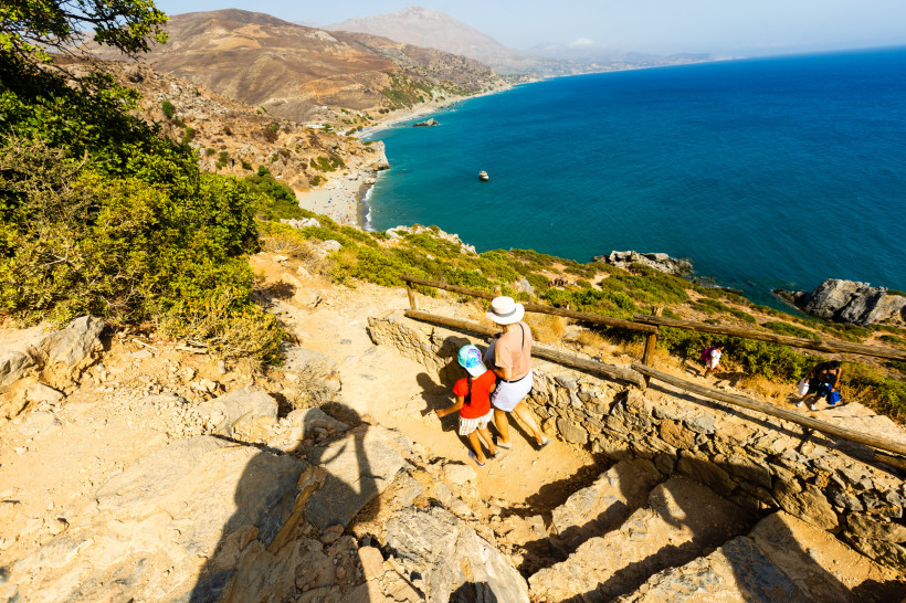Familie auf Wanderweg mit Blick auf die Bucht von Preveli Beach und das Meer