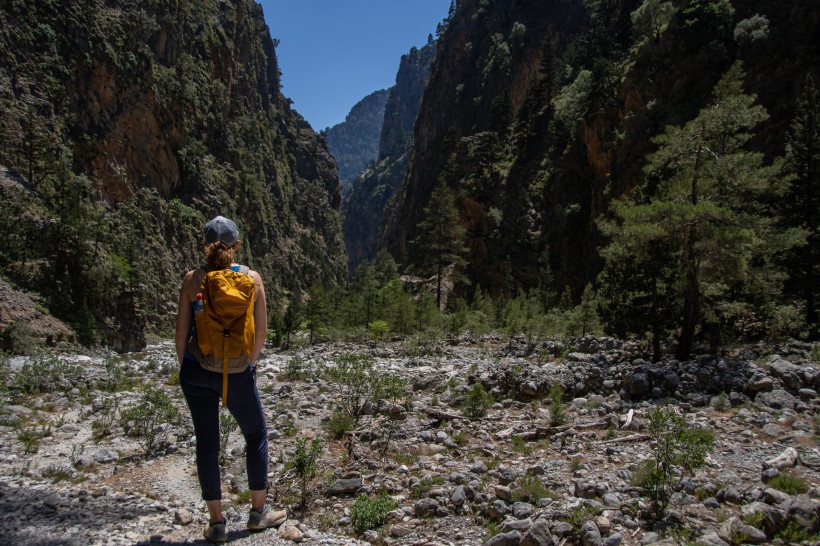Wanderin mit Rucksack in der Samaria-Schlucht zwischen steilen Felswänden