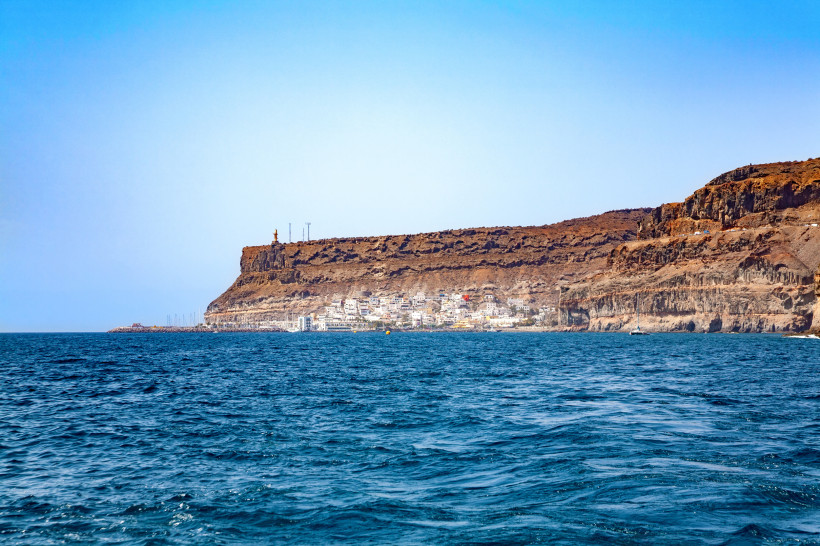 Puerto de Mogán: Küstenort mit Steilküste und Blick über das Meer Blick vom Meer auf Puerto de Mogán mit weißen Häusern am Fuß einer Steilküste