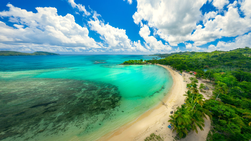 Dominikanische Republik - Playa Rincón  Bogenförmige Bucht mit türkisblauem Meer, hellem Sandstrand und Palmen in der Dominikanischen Republik – tropische Küstenlandschaft