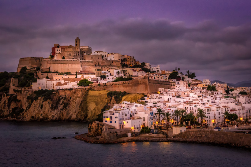 Abendansicht der Altstadt von Ibiza-Stadt mit Festungsmauern und weißen Häusern am Meer