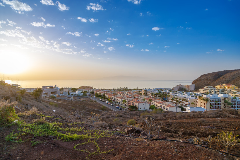 Palm-Mar Teneriffa – ruhiges Küstenresort mit Meerblick bei Sonnenuntergang Blick über Palm-Mar auf Teneriffa mit Häusern, Palmen, Hügeln und Meer im warmen Abendlicht