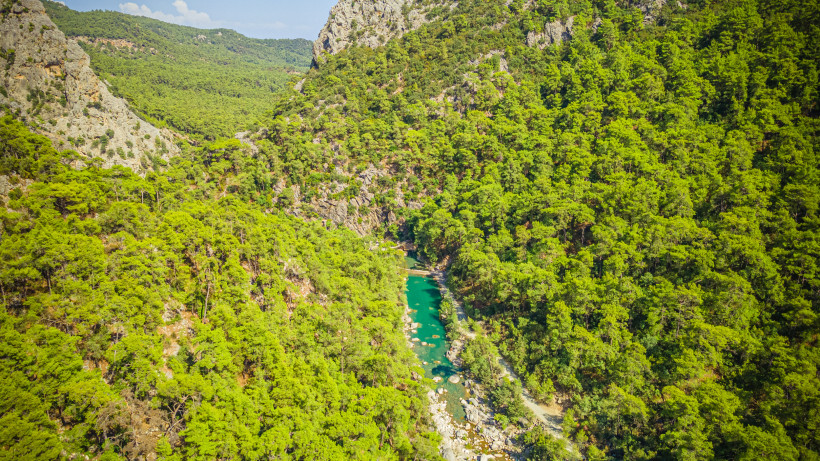 Luftaufnahme des Göynük-Canyons bei Kemer mit türkisfarbenem Fluss, dichter Waldlandschaft und Felsen im Taurusgebirge in der Türkei