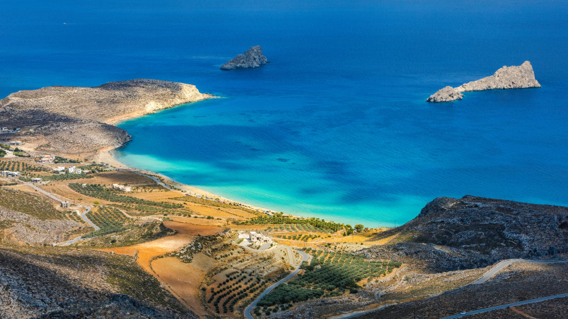 Bucht bei Xerokambos an der Südostküste Kretas mit türkisfarbenem Wasser, Sandstrand und kargen Hügeln