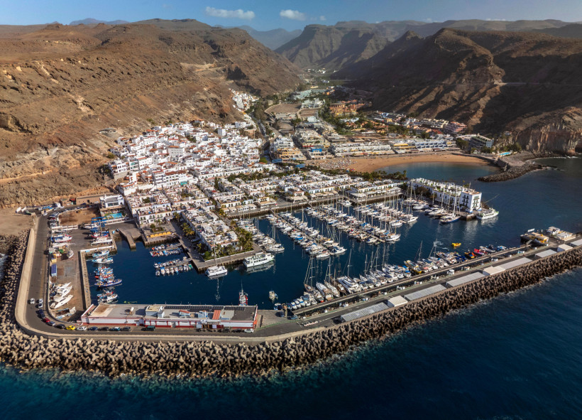 Luftaufnahme des Yachthafens und der Bebauung von Puerto de Mogán auf Gran Canaria, umgeben von felsigen Bergen