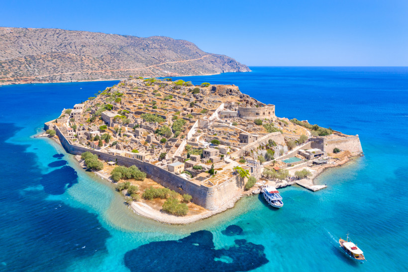 Luftaufnahme der Insel Spinalonga mit Festungsanlage und Ruinen im türkisblauen Meer vor der Küste Kretas