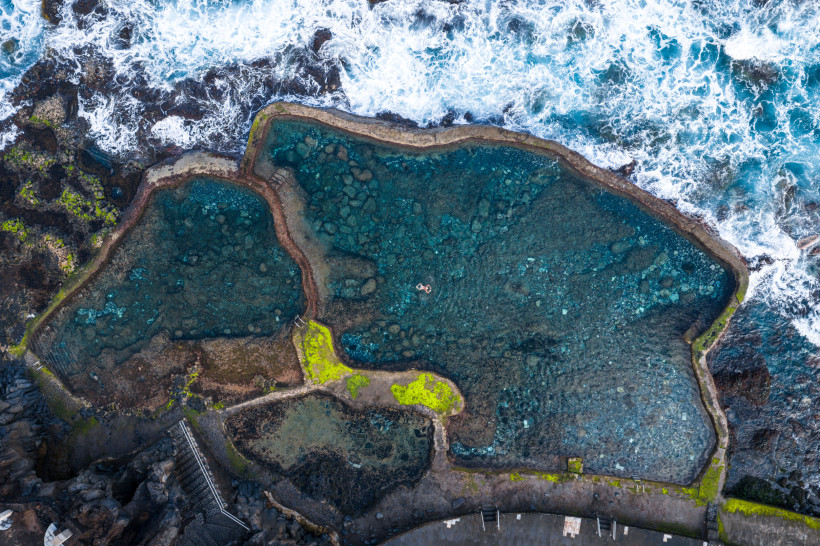 Luftaufnahme der Naturpools Charco Azul an der felsigen Küste von El Hierro mit Brandung und türkisfarbenem Wasser