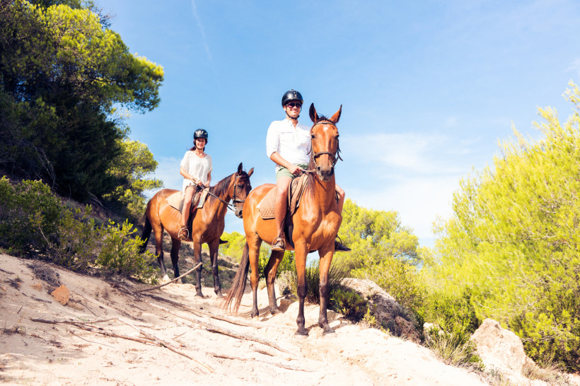 Paar bei einem geführten Ausritt durch die Landschaft nahe Cala Bona auf Mallorca