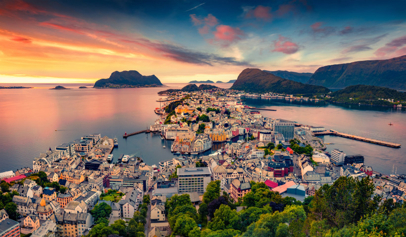 Ålesund: Blick über Hafen und Stadt mit Bergen im Hintergrund Panoramablick auf Ålesund mit Hafen, Stadtzentrum und umliegenden Bergen bei Sonnenuntergang