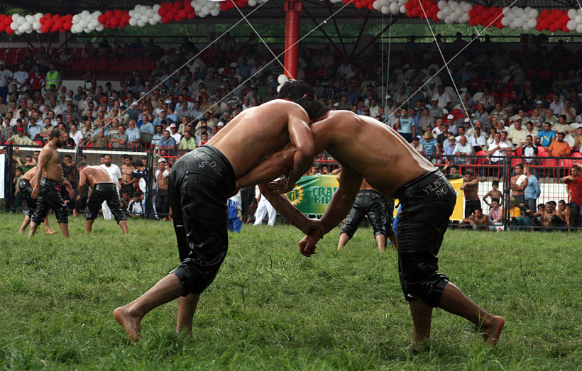 Türkei Mit bloßem Oberkörper, geölt und in traditionelle Lederhosen (Kispet) gekleidet, treten die Ringer auf der Wiese gegeneinander an. Yağlı Güreş ist mehr als ein Wettkampf – es ist ein kulturelles Spektakel mit tiefer historischer Bedeutung, begleitet von M
