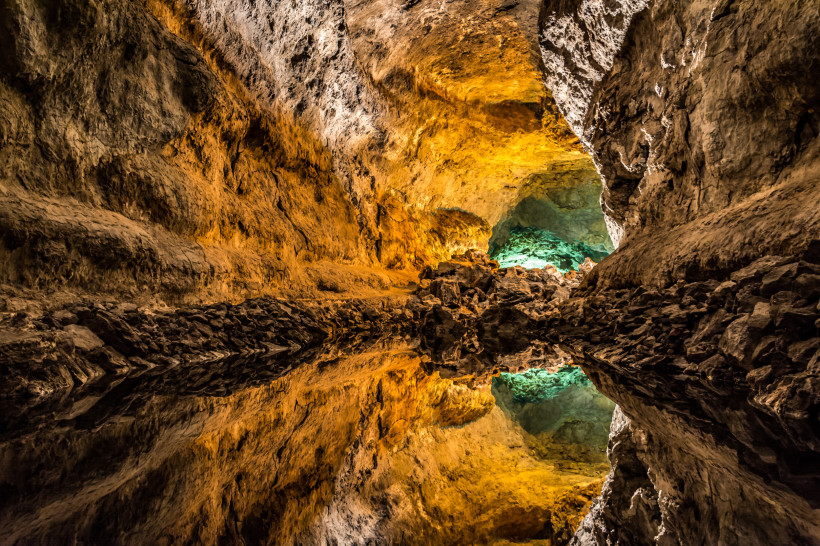 Cueva de los Verdes – Lavahöhle auf Lanzarote mit faszinierenden Farben Vulkanhöhle Cueva de los Verdes mit spiegelndem Wasser, beleuchtet in Gelb- und Grüntönen auf Lanzarote