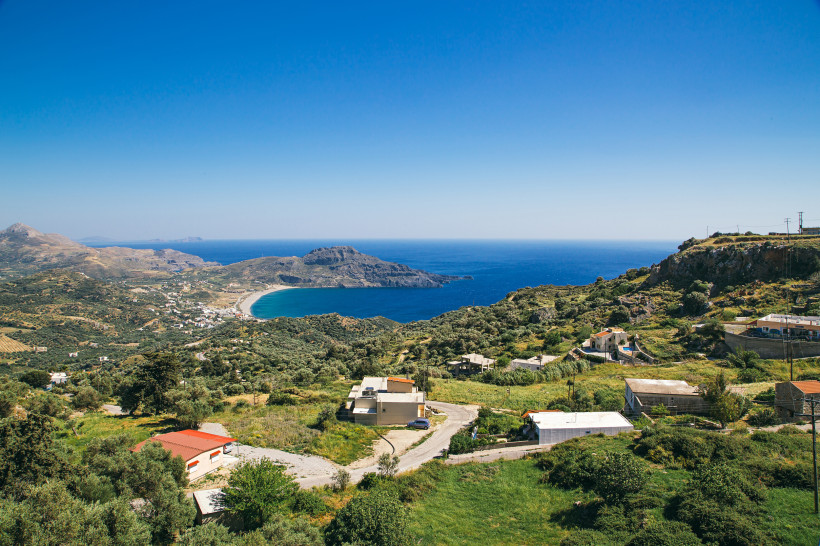 Blick über die Südküste Kretas mit Bucht, Meer und verstreuten Häusern in hügeliger Landschaft