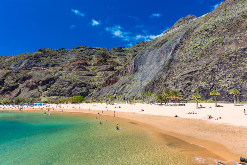 Playa de Las Teresitas in Santa Cruz de Tenerife Goldener Sandstrand Playa de Las Teresitas in Santa Cruz de Tenerife mit türkisblauem Meer, Palmen und grünen Berghängen im Hintergrund – einer der schönsten Strände im Norden Teneriffas.