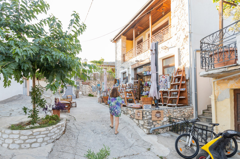 Gasse mit Souvenirgeschäften und Steinhäusern in einem Küstenort auf Kreta