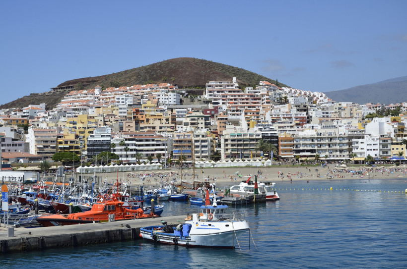 Hafenbecken mit Booten vor dem Strand und der Bebauung von Arona auf Teneriffa