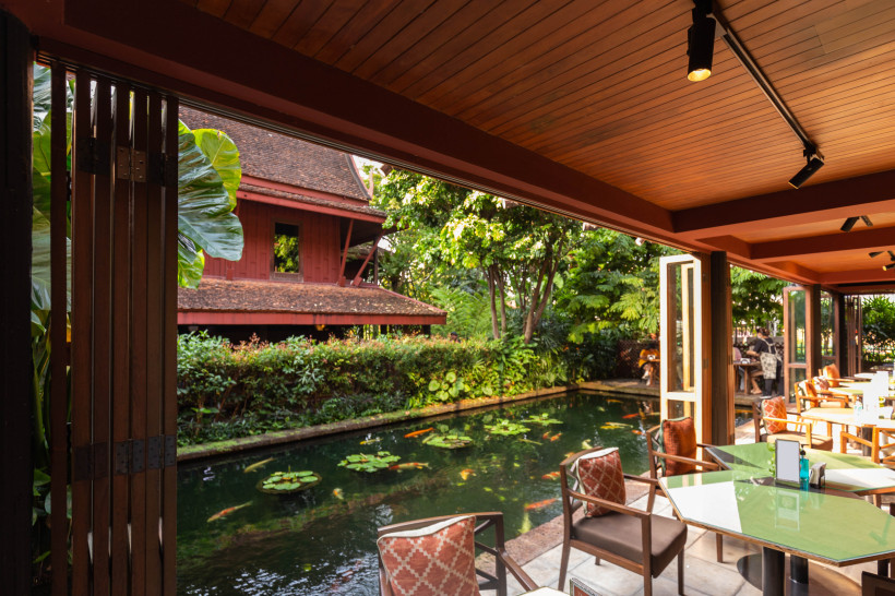 Café-Ausblick auf das Jim Thompson House mit Teich und tropischer Vegetation in Bangkok Blick vom Café auf das Jim Thompson House mit Fischteich, Seerosen und üppigem Garten in Bangkok
