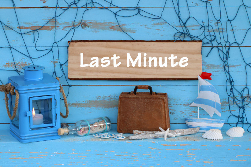 Last Minute Angebote – Maritime Deko mit Koffer und Laterne für kurzfristige Urlaubsbuchungen Maritime Deko mit Holzschild „Last Minute“, blauer Laterne, kleinem Koffer, Segelboot und Muscheln als Symbol für kurzfristige Urlaubsangebote.