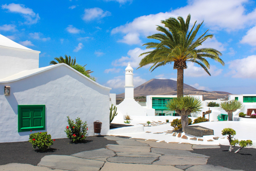 Tinajo Lanzarote – Weiß getünchte Häuser und Vulkanlandschaft bei Mancha Blanca Weiß gestrichene Häuser, Palmen und die vulkanische Landschaft rund um Tinajo und Mancha Blanca auf Lanzarote.