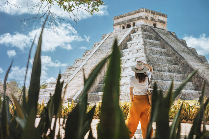 Mexiko junge Touristin mit Hut steht vor dem Hintergrund der Pyramide des Kukulcan in der alten mexikanischen Stadt Chichen Itza.