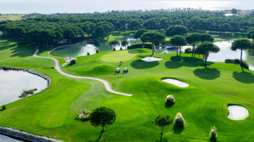 Aktivurlaub in Belek – Golfen auf wunderschönen Greens an der Türkischen Riviera Panorama eines gepflegten Golfplatzes in Belek mit grünen Fairways, Wasserhindernissen und umliegenden Pinien – ideal für Aktivurlauber und Naturfreunde