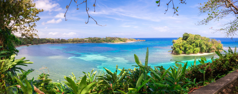 Panoramablick auf Port Antonio, Jamaika – türkisblaues Meer, tropische Vegetation und kleine Insel in karibischer Bucht.