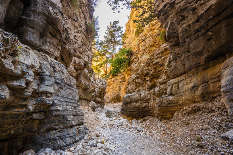 Imbros-Schlucht mit schmalem Geröllweg zwischen hohen Felswänden Blick in die Imbros-Schlucht mit steilen Felswänden, Geröllbett und vereinzelten Kiefern