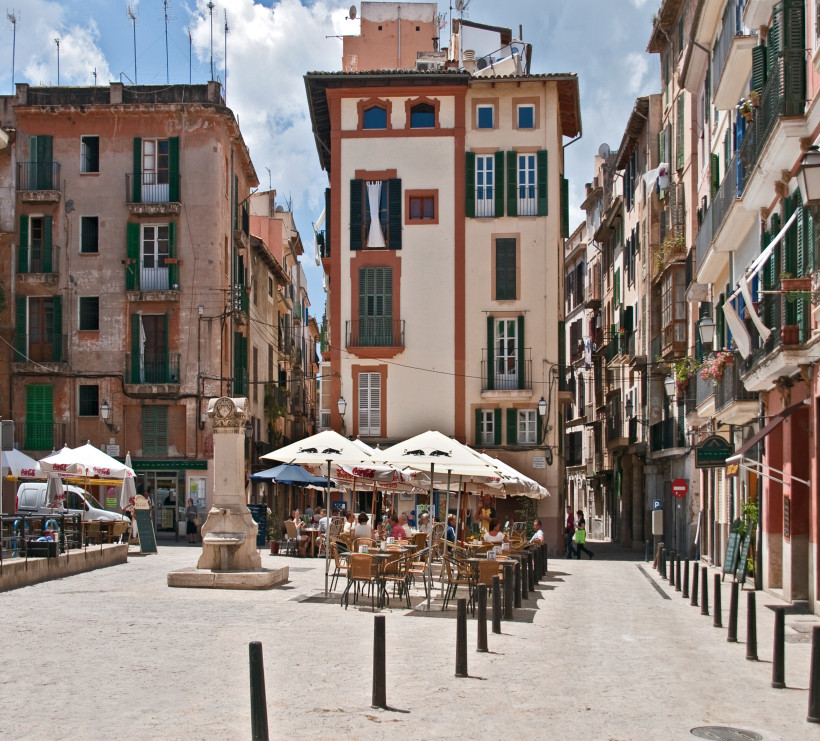 Platz in der Altstadt von Palma de Mallorca mit Straßencafés und mehrstöckigen Wohnhäusern