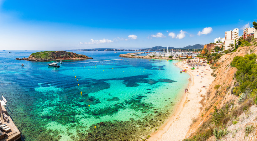 Puerto Portals Strand und Yachthafen im Südwesten Mallorcas Türkisfarbene Bucht bei Puerto Portals in Calvia mit Sandstrand, Yachten im Hafen und felsiger Küste im Südwesten von Mallorca.