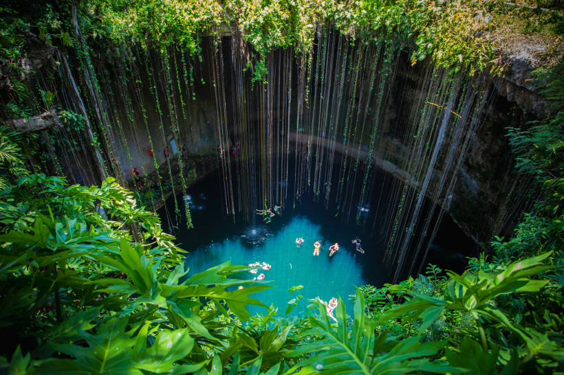 Mexiko Ik-Kil Cenote, Mexiko. Wunderschöne Cenote auf der Halbinsel Yucatan mit kristallklarem Wasser und hängenden Wurzeln