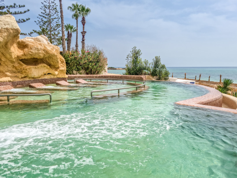 Pool mit Liegen im Wasser, Sonne scheint,Landschaft an einem Strand in Hammamet, Tunesien
