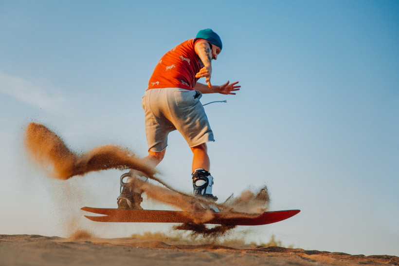 Abenteuer, Dubai Tourist beim Sandboarding in der Wüste