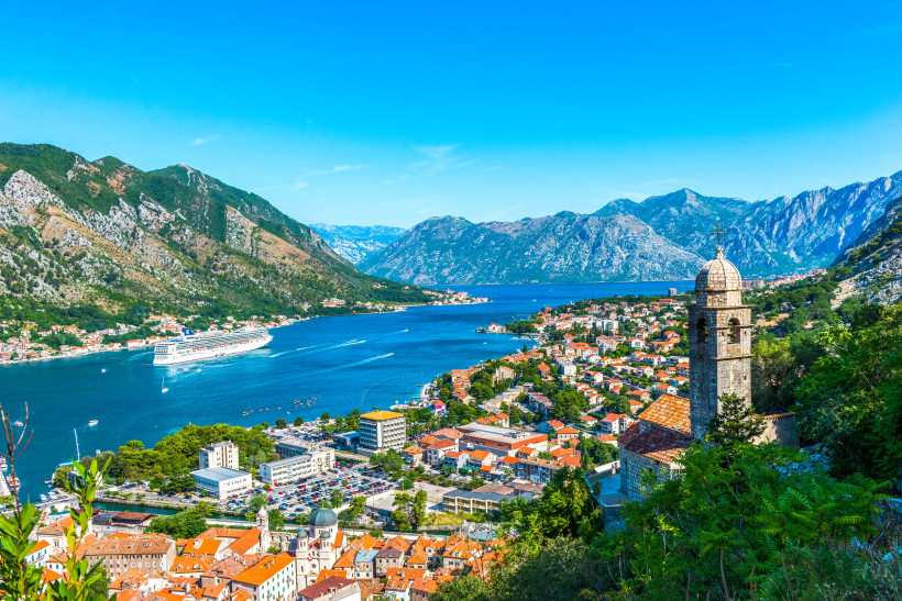 Blick über die Bucht von Kotor in Montenegro mit Altstadt, Bergen und Kreuzfahrtschiff