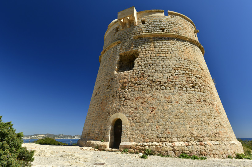 Torre des Carregador, runder Steinturm aus Naturstein mit Eingang und Aussichtsplattform unter blauem Himmel