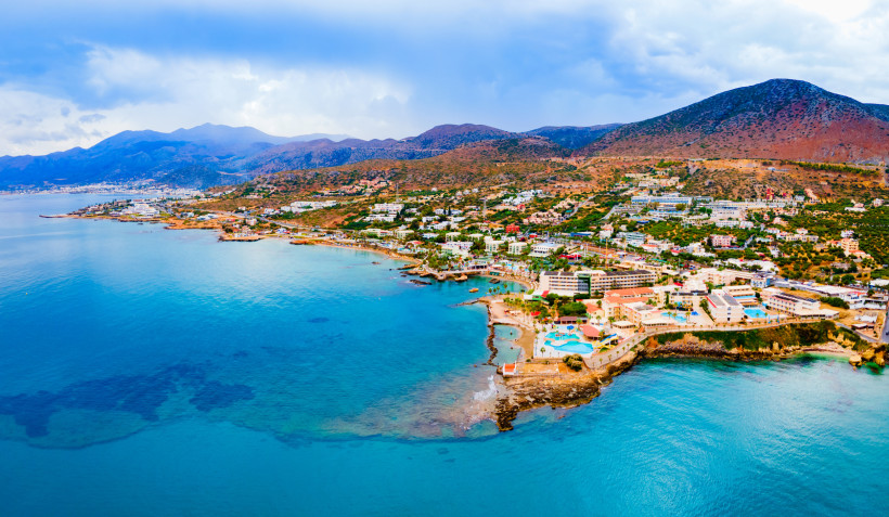 Küstenansicht von Chersonissos auf Kreta mit Hotels und Gebäuden am Meer vor Bergen