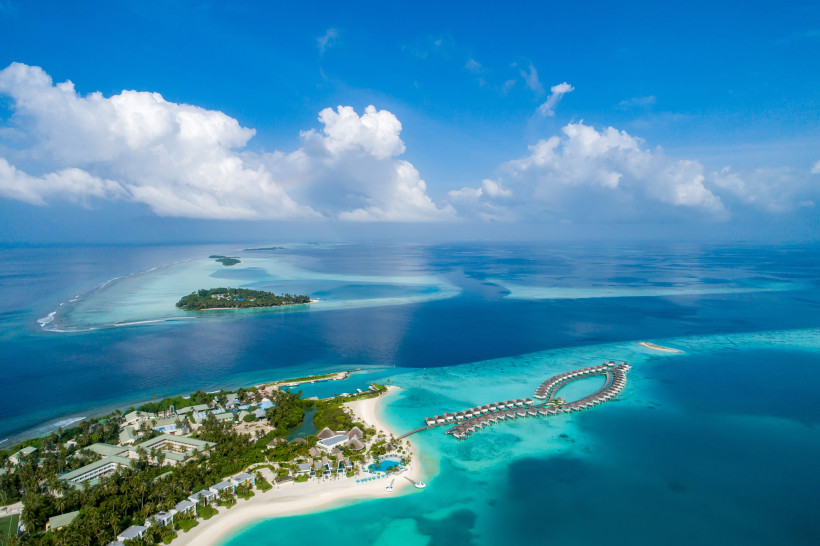 Luftaufnahme des Dhaalu-Atolls mit Sandstrand, Lagune und Überwasserbungalows
