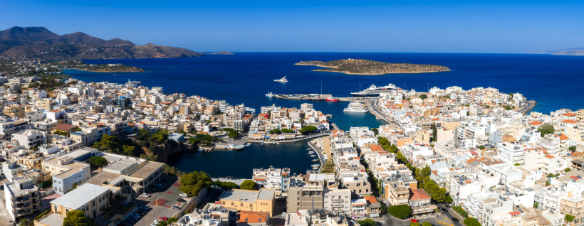Hafen und Küstenpanorama von Agios Nikolaos Blick über den Hafen von Agios Nikolaos mit Stadtbebauung, Lagune und Fähren vor der Küste
