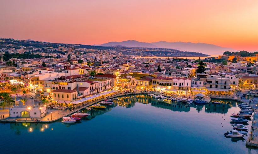 Venezianischer Hafen in Rethymno bei Sonnenuntergang mit Booten und Uferbebauung